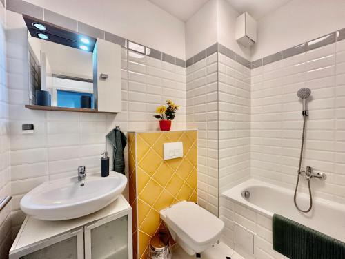 a bathroom with a sink and a toilet and a tub at Panorama Apartment #W6 #Terrace #FreeParking in Budapest