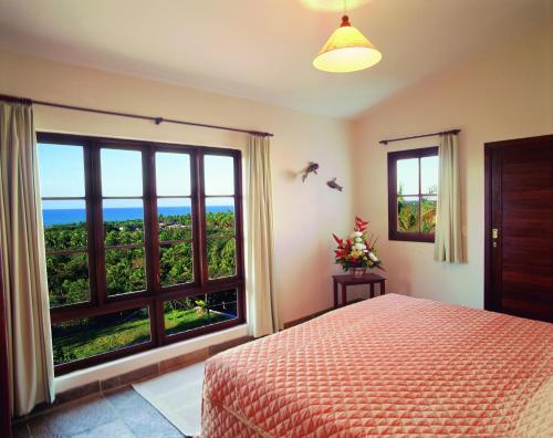 a bedroom with a bed and a large window at Hotel Varandas Mar De Pipa in Pipa