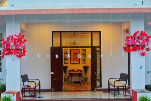a front door of a building with chairs and flowers at Jass Bagh Home stay Udaipur I swimming pool I wedding I 946o1o3906 in Udaipur