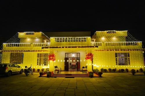 a yellow building with lights on it at night at Jass Bagh Home stay Udaipur I swimming pool I wedding I 946o1o3906 in Udaipur