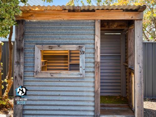 a small blue outhouse with a window at Hampton's Style Holiday Retreat - close to the beach! in Encounter Bay