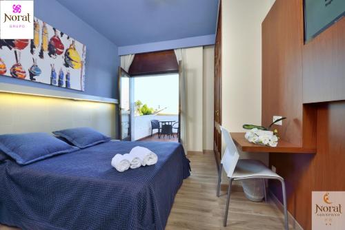 a bedroom with a bed and a desk with towels on it at Nuevo Norat Sanxenxo in Sanxenxo