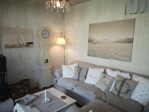 a living room with a couch and a clock on the wall at Countryhouse Lake Attersee - Traumhaft schöne Lage - Bezauberndes Hideaway in Unterach am Attersee