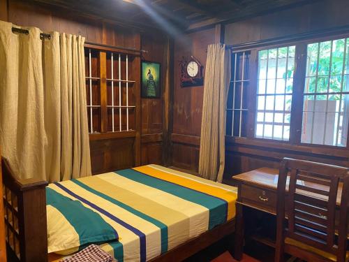 a small bedroom with a bed and a window at Mayoorapanjaram in Neyyāttinkara