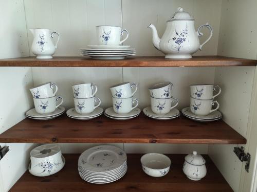 a shelf with dishes and cups and plates on it at Countryhouse Lake Attersee - Traumhaft schöne Lage - Bezauberndes Hideaway in Unterach am Attersee