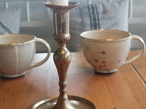 two cups and a candle holder on a table at Countryhouse Lake Attersee - Traumhaft schöne Lage - Bezauberndes Hideaway in Unterach am Attersee