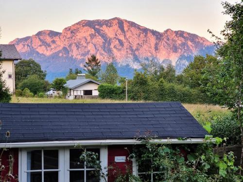a house with a roof with mountains in the background at Countryhouse Lake Attersee - Traumhaft schöne Lage - Bezauberndes Hideaway in Unterach am Attersee