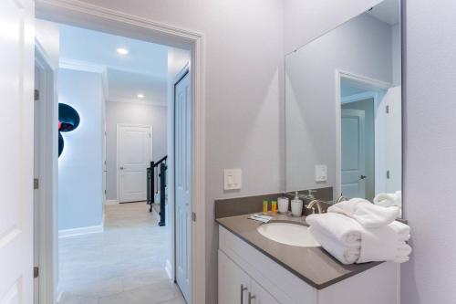 ein Badezimmer mit Waschbecken und Spiegel in der Unterkunft Thematic house near DisneyGame Room in Kissimmee