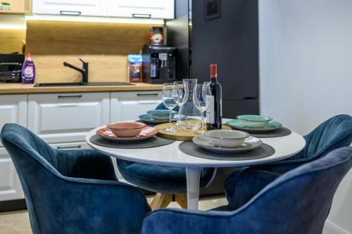 una mesa con platos y copas de vino en la cocina en Five Stars Apartment, en Timisoara