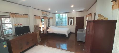 a room with a bedroom with a bed and a television at Pasak River House Home stay 