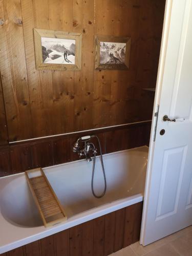 a bath tub in a bathroom with a wooden wall at Countryhouse Lake Attersee - Traumhaft schöne Lage - Bezauberndes Hideaway in Unterach am Attersee