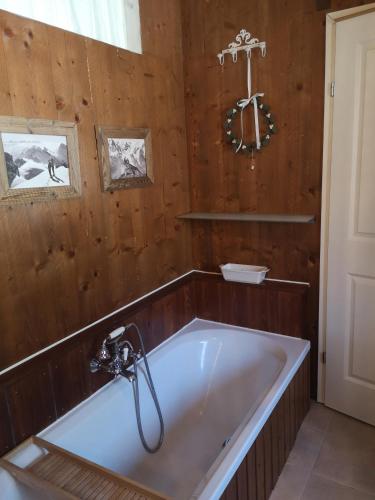 a bath tub in a room with a wooden wall at Countryhouse Lake Attersee - Traumhaft schöne Lage - Bezauberndes Hideaway in Unterach am Attersee