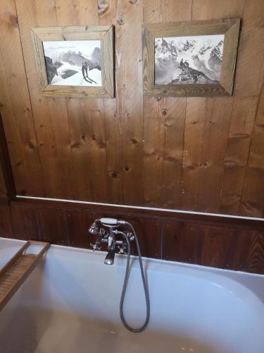 a bathroom with a bath tub with two pictures on the wall at Countryhouse Lake Attersee - Traumhaft schöne Lage - Bezauberndes Hideaway in Unterach am Attersee