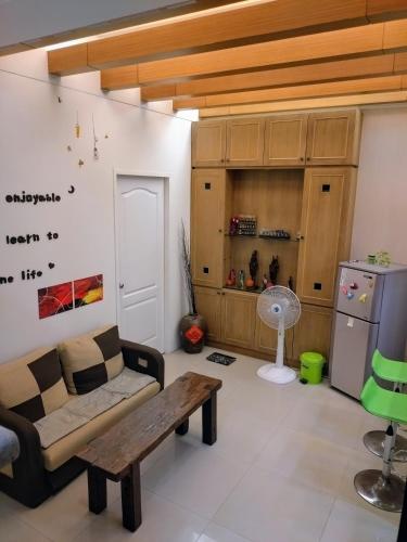 a living room with a couch and a table and a refrigerator at 1986 Travel Hall in Tainan