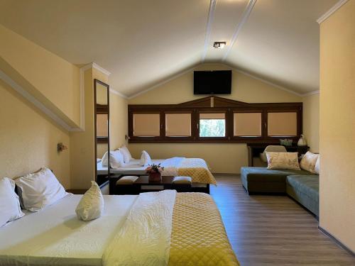 LipovaにあるCasa Maria Magdalenaのベッド2台とソファが備わるホテルルームです。