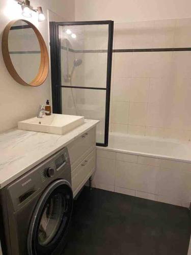 une salle de bain avec une machine à laver et un lavabo dans l'établissement Le Parisien - Bel Appartement à 10mn de Paris, à Suresnes