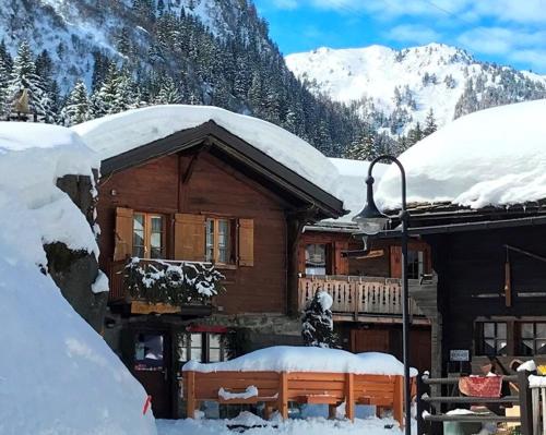 a log cabin with snow on the roof of it at BnB Le Mazot Fionnay in Fionnay