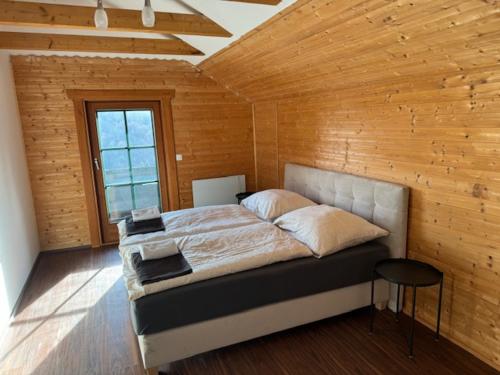a bedroom with a bed in a wooden wall at Ferienhaus Maximilian in Gamlitz
