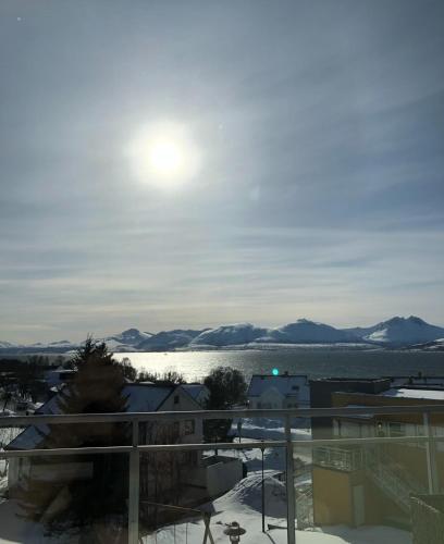 a view of the water and mountains from a balcony at Arctic Homestay with Northern light view room in Tromsø