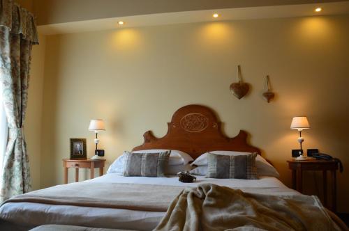 a bedroom with a large bed with a wooden headboard at Hotel Garn&igrave; Carpe Diem in Vigo di Fassa