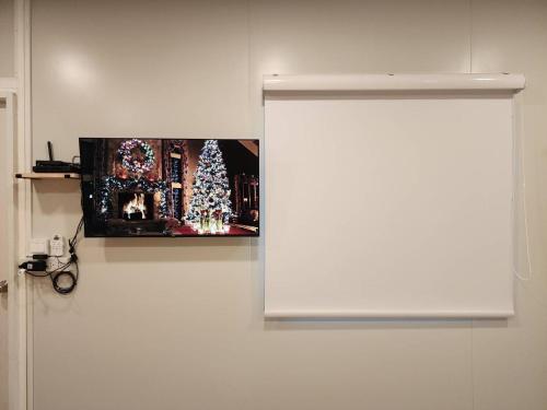 a white wall with a picture of a christmas tree at Phusira ภูศิรา กาญจนบุรี 