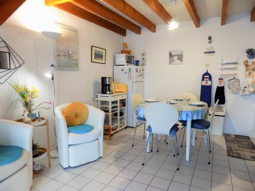 une cuisine avec une table, des chaises et un réfrigérateur dans l'établissement Saint Palais sur Mer - COEUR du PLATIN - VILLA en RESIDENCE 5 min PLAGE, à La Palud