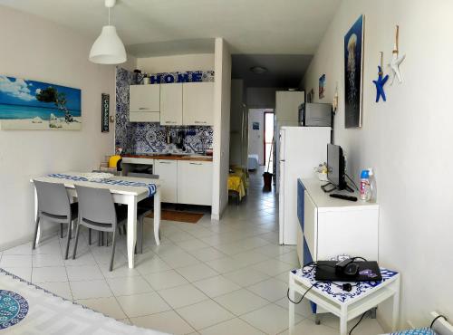 a kitchen and dining room with a table and a refrigerator at Casa vacanze Romax San Vito Lo Capo in San Vito lo Capo