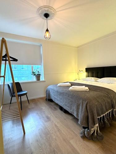 a bedroom with a bed and a chair and a window at Day Dream Laugavegur Downtown Apartments in Reykjavík