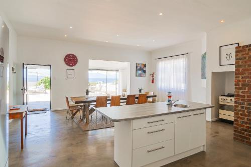 a kitchen and dining room with a table and chairs at 38 on Westcliff in Hermanus