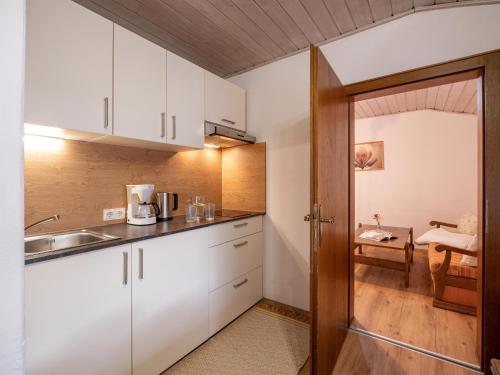 uma cozinha com armários brancos e um lavatório em Bauernhof Hanslingerhof em Wörgl
