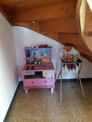 różowy stół i krzesło w pokoju w obiekcie Böglihuus w mieście Bellelay