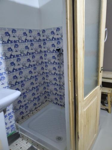 a bathroom with a shower with blue and white tiles at Homelidays in Ivato