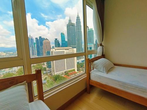 a room with two beds and a large window at Habibi HoMe KLCC in Kuala Lumpur