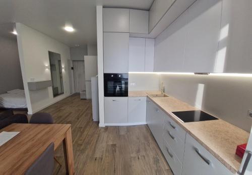 a kitchen with white cabinets and a counter top at ApartPlus - Затишні апартаменти in Dnipro
