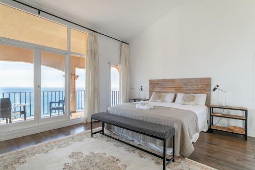 a white bedroom with a bed and a balcony at Almela's in Santa Pola