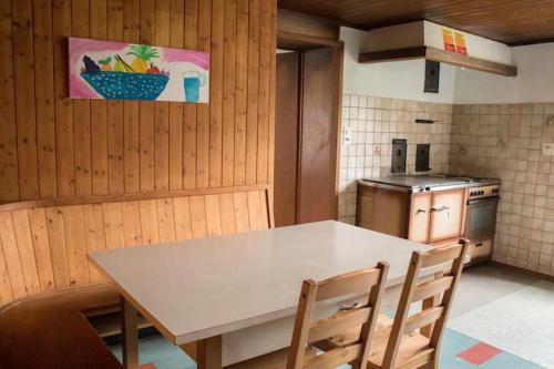 kuchnia ze stołem i krzesłami w pokoju w obiekcie Böglihuus w mieście Bellelay