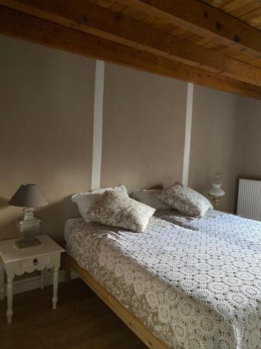 a bedroom with a bed with white sheets and pillows at Grande Chambre d'hôte in Chalmazel Jeansagniere