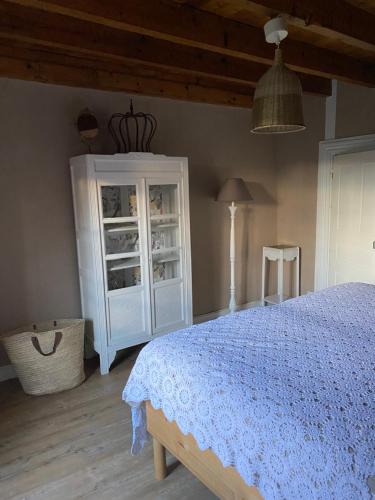 a bedroom with a bed and a white cabinet at Grande Chambre d'hôte in Chalmazel Jeansagniere