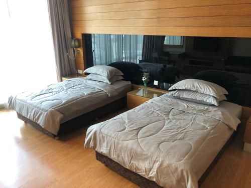 Duas camas num quarto com uma cabeceira em Backpackers Cozy Apartment KL Sentral em Kuala Lumpur