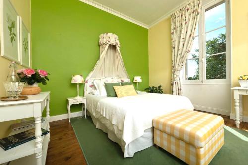 a bedroom with a white bed and green walls at Chateau Carbonneau in Pessac-sur-Dordogne