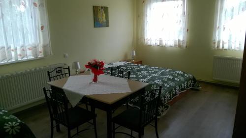 a room with a table with chairs and a bed at DUO Apartmanok in Sárvár