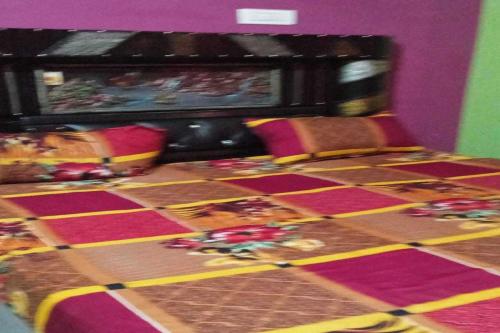 a room with a bed with a checkeredkered floor at POP Pinki Homestay in Arli