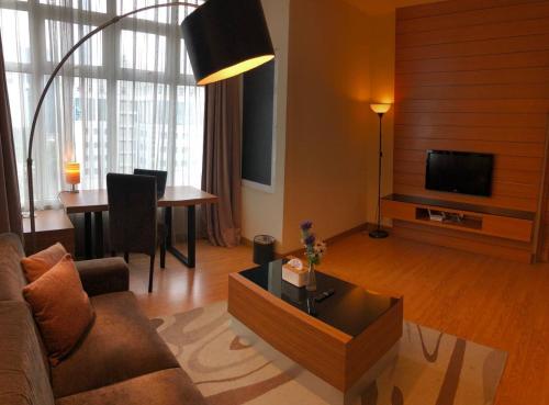 uma sala de estar com um sofá e uma mesa em Backpackers Cozy Apartment KL Sentral em Kuala Lumpur