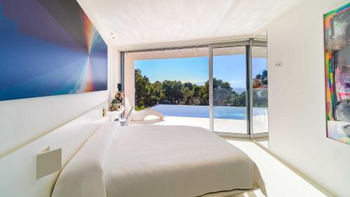 a bedroom with a bed and a large window at Villa Iris Javea by Rock Rentals in Balcon del Mar