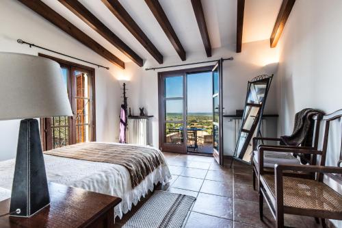 a bedroom with a bed and a table and a window at Finca Relax Can Mengol amazing seaview in Artá