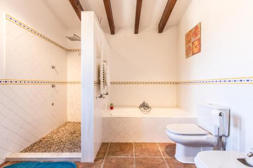 a bathroom with a toilet and a tub and a sink at Finca Relax Can Mengol amazing seaview in Artá