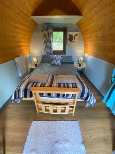 a bedroom with a large bed in a cabin at Country pod with wood fired hot tub in Clodock