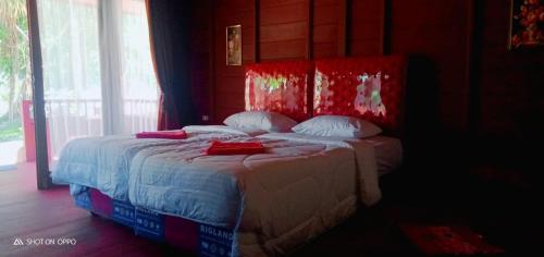 a bedroom with a bed with a red head board at Raflow Resort Raja Ampat in Tapokreng