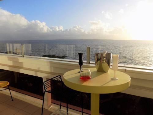 - une table sur un balcon avec vue sur l'océan dans l'établissement Royan - PLEINE VUE MER pour cet APPARTEMENT classé 2 étoiles - LES TAMARIS, à Royan