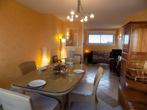 une salle à manger avec une table et des chaises dans l'établissement Royan - PLEINE VUE MER pour cet APPARTEMENT classé 2 étoiles - LES TAMARIS, à Royan